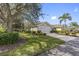 Beautiful single-story home with a well-manicured lawn, mature trees, and a spacious driveway at 988 Villeroy Greens Dr, Sun City Center, FL 33573