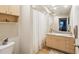 Bright bathroom features wooden cabinets, a sink, a mirror, and a shower at 100 4Th S Ave # 109, St Petersburg, FL 33701