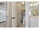 Powder room showing toilet with modern fixtures, with view to Primary bath and Primary bedroom at 10136 Grand Oak Cir, Madeira Beach, FL 33708