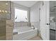 Bathroom showcasing a soaker tub under a window with a tiled surround next to a tiled shower at 10136 Grand Oak Cir, Madeira Beach, FL 33708