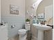 Charming powder room with wainscoting, pedestal sink, and coastal-themed decor at 10136 Grand Oak Cir, Madeira Beach, FL 33708