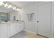 Bathroom featuring double sink vanity with granite countertop and framed mirror and tile floors at 10136 Grand Oak Cir, Madeira Beach, FL 33708