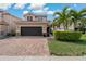 Charming two-story home with a well-manicured lawn, beautiful red brick driveway and tile roof at 10136 Grand Oak Cir, Madeira Beach, FL 33708