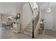 Bright foyer area features a staircase with rod iron railings and a modern light fixture at 10136 Grand Oak Cir, Madeira Beach, FL 33708