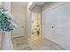 Entryway with neutral decor leading to a powder room, with ceramic tile flooring and white doors at 10136 Grand Oak Cir, Madeira Beach, FL 33708