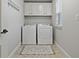 Well-organized laundry room with washer, dryer, and overhead storage at 10136 Grand Oak Cir, Madeira Beach, FL 33708
