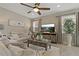 Cozy living room features a ceiling fan, tile floors, neutral colors, and lots of natural light at 10136 Grand Oak Cir, Madeira Beach, FL 33708