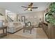 Spacious living room features tile floors, neutral colors, ceiling fan, and a stairway at 10136 Grand Oak Cir, Madeira Beach, FL 33708