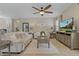 Open living room featuring neutral colors, tile flooring, ceiling fan, and a large TV at 10136 Grand Oak Cir, Madeira Beach, FL 33708