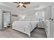 Spacious main bedroom showcasing a tray ceiling, ceiling fan, a large mirror and wood look tile flooring at 10136 Grand Oak Cir, Madeira Beach, FL 33708