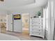 Bright main bedroom featuring a light dresser and showing the ensuite bathroom and adjoining living room at 10136 Grand Oak Cir, Madeira Beach, FL 33708