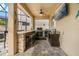 Outdoor kitchen with stone bar, grill, beverage cooler, tv and seating at 10136 Grand Oak Cir, Madeira Beach, FL 33708