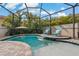 Beautiful pool area with waterfall feature, surrounded by tropical landscaping at 10136 Grand Oak Cir, Madeira Beach, FL 33708