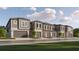 Exterior of new townhomes with neutral color palette, garages, and landscaping on a sunny day at 10807 Fort White Ct, Tampa, FL 33647