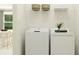 Bright laundry room featuring a white washer and dryer with overhead storage and neutral decor at 11870 Sparkling Topaz Cv, Parrish, FL 34219