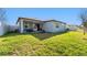 A view of the home's exterior, fenced backyard, and patio furniture at 12593 Palapa Loop, Spring Hill, FL 34610