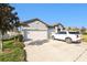 This single-story home has a spacious driveway, an attached garage, and a neutral exterior paint scheme at 12593 Palapa Loop, Spring Hill, FL 34610