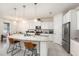 Bright kitchen features white cabinets, stainless steel appliances, granite countertops, and a large central island at 12593 Palapa Loop, Spring Hill, FL 34610
