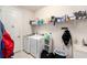 Efficient laundry room with modern washer and dryer, shelving, and ample space at 12593 Palapa Loop, Spring Hill, FL 34610