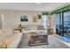 Comfortable living room with neutral tones, ceiling fan and access to the screened lanai at 1424 Pine Glen Ln # B2, Tarpon Springs, FL 34688