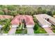 Expansive aerial view of a home with red tile roof, lush landscaping, and a paver driveway at 16112 Amethyst Key Dr, Wimauma, FL 33598