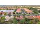 Aerial view of a community with lush landscaping, lake views, and homes with red tile roofs at 16112 Amethyst Key Dr, Wimauma, FL 33598