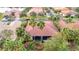 Aerial view of home with a red tile roof, screened-in patio, and surrounded by lush tropical landscaping at 16112 Amethyst Key Dr, Wimauma, FL 33598