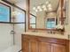Elegant bathroom with a double vanity, granite countertop, and glass shower enclosure at 16112 Amethyst Key Dr, Wimauma, FL 33598