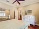 Relaxing bedroom with wood floors, white dresser, walk-in closet and natural light at 16112 Amethyst Key Dr, Wimauma, FL 33598