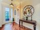 Entryway with hardwood floors and a decorative table with a round mirror at 16112 Amethyst Key Dr, Wimauma, FL 33598