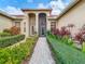 Beautiful home exterior featuring lush landscaping and a brick walkway to the front door at 16112 Amethyst Key Dr, Wimauma, FL 33598
