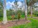 Picture-perfect backyard with well-maintained landscaping, colorful plants, and mature trees at 16112 Amethyst Key Dr, Wimauma, FL 33598