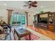 Cozy living room with hardwood floors, a ceiling fan, and sliding glass doors to the patio at 16112 Amethyst Key Dr, Wimauma, FL 33598