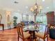 Open concept living room featuring hardwood floors, chandelier, and access to outdoor space at 16112 Amethyst Key Dr, Wimauma, FL 33598