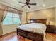 Comfortable main bedroom with a ceiling fan, hardwood floors, and a view of the outdoors at 16112 Amethyst Key Dr, Wimauma, FL 33598