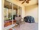 Inviting covered patio with brick flooring, wicker seating, and view to landscaped backyard through sliding glass door at 16112 Amethyst Key Dr, Wimauma, FL 33598