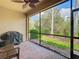 Screened-in patio featuring brick flooring and views of the lush, green landscaping and mature trees in the backyard at 16112 Amethyst Key Dr, Wimauma, FL 33598