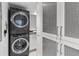 Convenient laundry area showcasing stacked washer/dryer and modern ventilated white cabinetry at 1660 Gulf Blvd # Ph2, Clearwater Beach, FL 33767