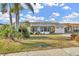 Attractive single-story home with lush tropical landscaping and inviting screened porch at 1740 Coco Palm Cir, Sun City Center, FL 33573