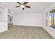 Bright living room features wood-look floors, ceiling fan, and large windows for natural light at 1740 Coco Palm Cir, Sun City Center, FL 33573