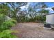 View of a backyard with a dirt lot, shrubbery, and an AC unit in the corner at 1931 24Th S St, St Petersburg, FL 33712