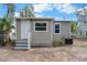 Backyard view of detached unit with white door, modern windows and neutral gray color scheme at 1931 24Th S St, St Petersburg, FL 33712