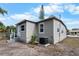 Side view of home with gray siding, updated windows, and a modern air conditioning unit at 1931 24Th S St, St Petersburg, FL 33712