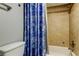 A well-lit bathroom with a tub and shower, featuring tiled walls and a seashell-themed shower curtain at 200 Country Club Dr # 503, Largo, FL 33771