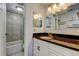 Bathroom features granite counters, white cabinetry, tiled shower with tub, and updated lighting at 200 Country Club Dr # 503, Largo, FL 33771