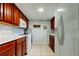 Efficient kitchen featuring white appliances, wooden cabinets, and tile backsplash at 200 Country Club Dr # 503, Largo, FL 33771