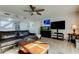 Open-concept living room with ceiling fan, dark-colored sofa, and entertainment center at 200 Country Club Dr # 503, Largo, FL 33771