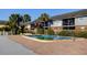 Community pool and building exterior with palm trees and sunny skies at 200 Country Club Dr # 503, Largo, FL 33771