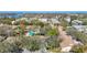 Aerial view of villas with a pool and mature trees, with waterfront condos in the distance at 2606 Oak Cir, Tarpon Springs, FL 34689