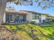 Inviting backyard featuring mature trees, lush lawn, a screened-in lanai, and ample space for outdoor enjoyment at 2606 Oak Cir, Tarpon Springs, FL 34689
